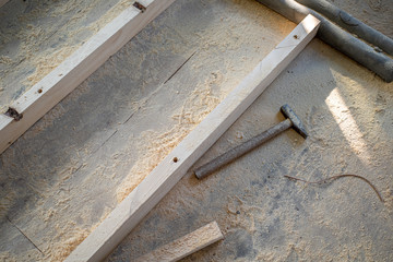  hammer covered with sawdust lies at the bottom of a construction site