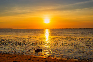 Beautiful summer beach and sea and yellow orange sky at the sunset, twilight period which including of sunrise