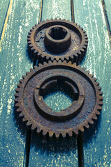 Old rusty gears on a wooden table set in the shape of number eight.