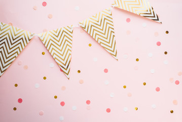 Template for the holidays. Paper garland of flags on a pink background with confetti