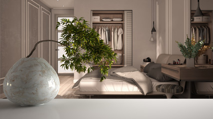 White mat table shelf with round marble vase and potted bonsai, green leaves, over classic bedroom in beige tones, bed with duvet and pillows, zen clean architecture concept idea