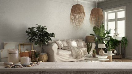Wooden vintage table top or shelf with candles and pebbles, zen mood, over old style living room in beige tones, sofa, carpet, tables and plants, white architecture interior design