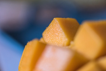 Mango on the wooden table, with cut pieces and complete
