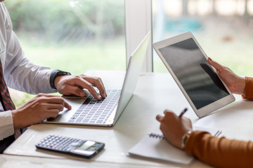 Business people working together with tablet and laptop computer in the office.