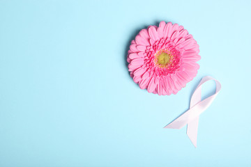 pink ribbon, gerbera and stethoscope on a colored background top view. Symbol of female cancer....