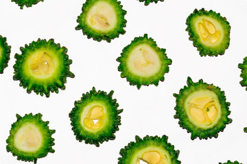 Green colorful bitter gourd vegetable round slices on white background.