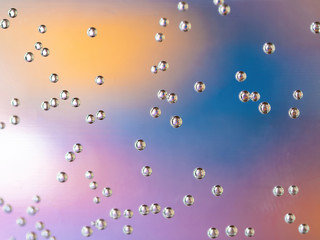 air bubbles on water glass with orange and blue background