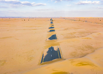 Aerial view of half desert road or street with sand dune in Dubai City, United Arab Emirates or...