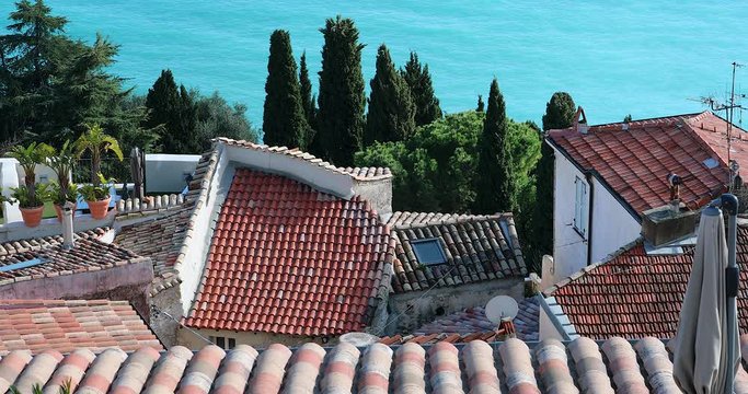 Aerial View Of The Tiles On The Roofs Of The Village Houses, Turquoise Blue Water Of The Mediterranean Sea In The Background, Roquebrune-Cap-Martin On The French Riviera - DCi 4K Resolution