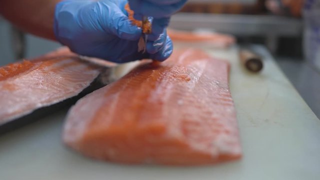 Chef use tweezers removing salmon fishbone