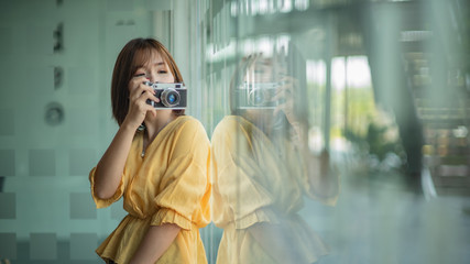 Asian woman photographer take a picture by film camera