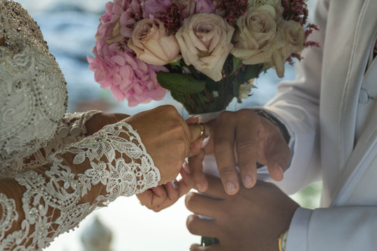 Manos de una pareja coloc&aacute;ndose el ani&ntilde;o en la boda