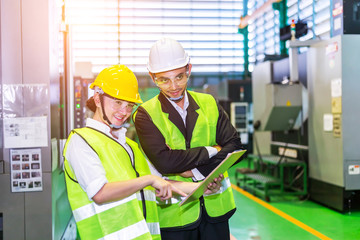 Female and male engineers are inspecting machine operations and controlling product quality.