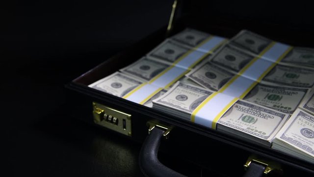 Stacks of 100 dollar bills in a briefcase , briefcase full of money .