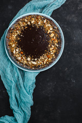 Chocolate cake, chocolate cake, dessert with nuts. Roasted peanuts, almonds and hazelnuts. On dark background. The view from the top. The view from the side. Space for text.