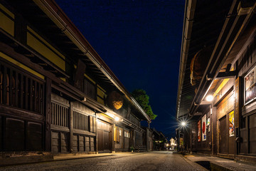 Fototapeta na wymiar Night view of Sannomachi Street in Takayama, with old wooden buildings and houses dating from the Edo Period, Japan