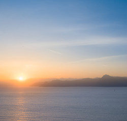 quiet sea bay with rocky coast at the sunset