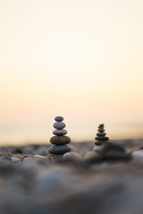 Balanced stone pyramid on pabbles beach with sunset. Zen rock, concept of balance and harmony.