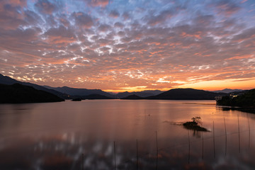 Obraz premium The sunset cloud has dyed the lake red, and the sky is connected with the water