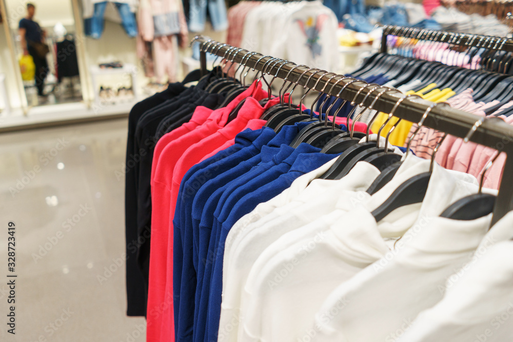 Canvas Prints Fashionable clothes on hangers in a store.