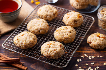 Oat vegan cookies on cooling rack with cup of tea. Wooden background.