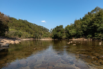 Under the blue sky, the rural lake reflects the landscape