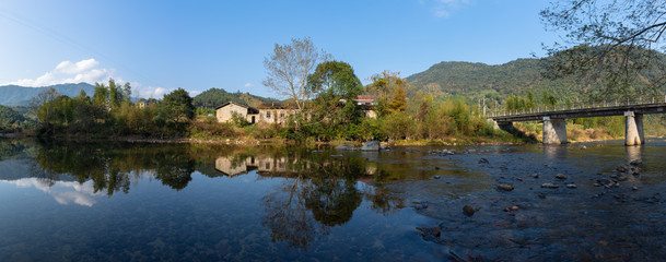 Fototapeta premium Under the blue sky, the rural lake reflects the landscape