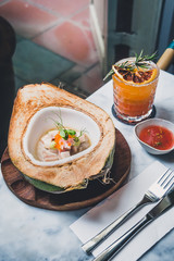 Hamachi and Coconut Ceviche Hamachi aguachile on a fresh, green coconut, hibiscus flower milk, trout roe and avocado puree