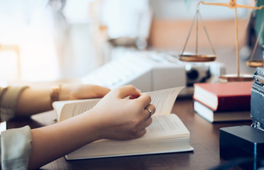 Female lawyer reading legal books while she working on desk