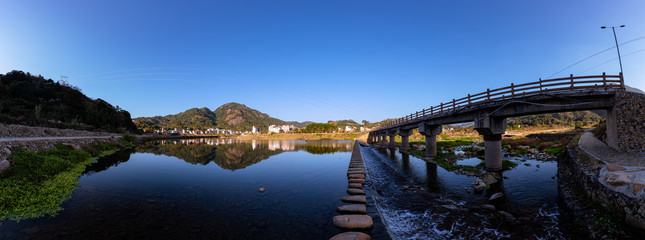 Under the blue sky, the rural lake reflects the landscape