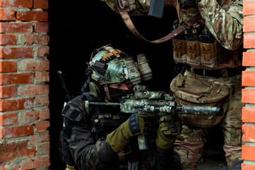 Closeup two men in camouflage cloth green and black uniform with machineguns. Soldiers with...