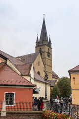 Fototapeta premium Fragment of Small Square with clocktower of Lutheran Cathedral of Saint Mary in a rainy day in Sibiu city in Romania