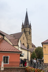 Fototapeta na wymiar Fragment of Small Square with clocktower of Lutheran Cathedral of Saint Mary in a rainy day in Sibiu city in Romania