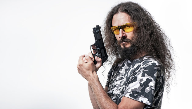 Portrait of the skinny, funny man holding a gun