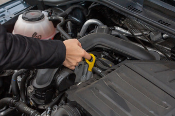 Closeup woman hands repairing a car. Women makes service control of a vehicle.