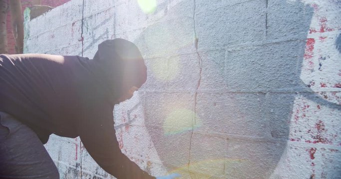 Mural Artist spray painting a wall. 