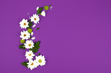 Background with white flowers and empty notebook for text on purpule table. Place for text. Top view with copy space