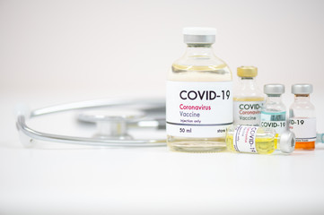 Vaccine bottles, syringe and stethoscope on white background.Vaccination against coronavirus quarantine or covid-19.Protection against virus and infection control.Medication treatment concept.