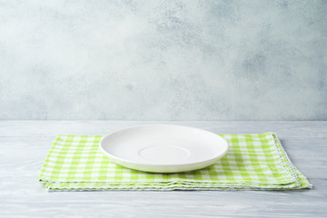 Empty plate with tablecloth on wooden table. Spring and easter mock up for design