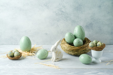 Easter holiday decorations with easter eggs, bunny and bird nest on wooden table