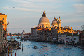 Fototapeta na wymiar View of the Grand Canal in Venice during sunset. Ttraditional gondolas and boats with passengers.