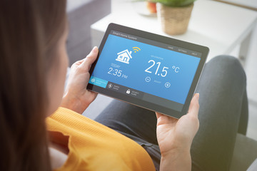 Woman using smart home application on tablet.