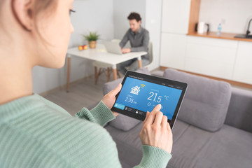 Woman using smart home application on tablet.