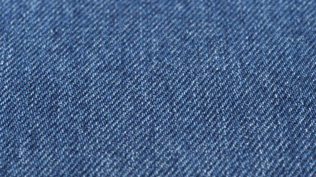 Jeans fabric close up tracking. Denim textile texture. Slider shot. Low angle, macro. 4K, 422 10 bit
