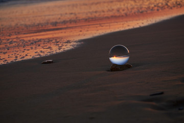 Obraz premium Tramonto sulla spiaggia salentina con sfera di cristallo