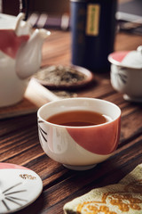 Japanese tea into asian porcelain cup on wood table