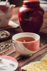 Japanese tea into asian porcelain cup on wood table
