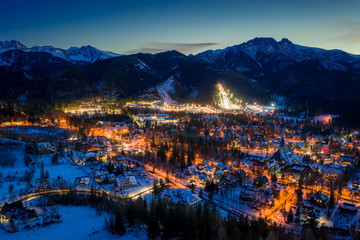 Wonderful illuminated Zakopane city in winter at night, aerial view - obrazy, fototapety, plakaty
