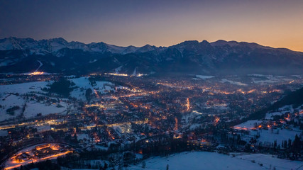 Beautiful illuminated Zakopane city in winter at night, aerial view