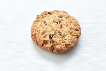 Oatmeal cookies and chocolate chips on light background